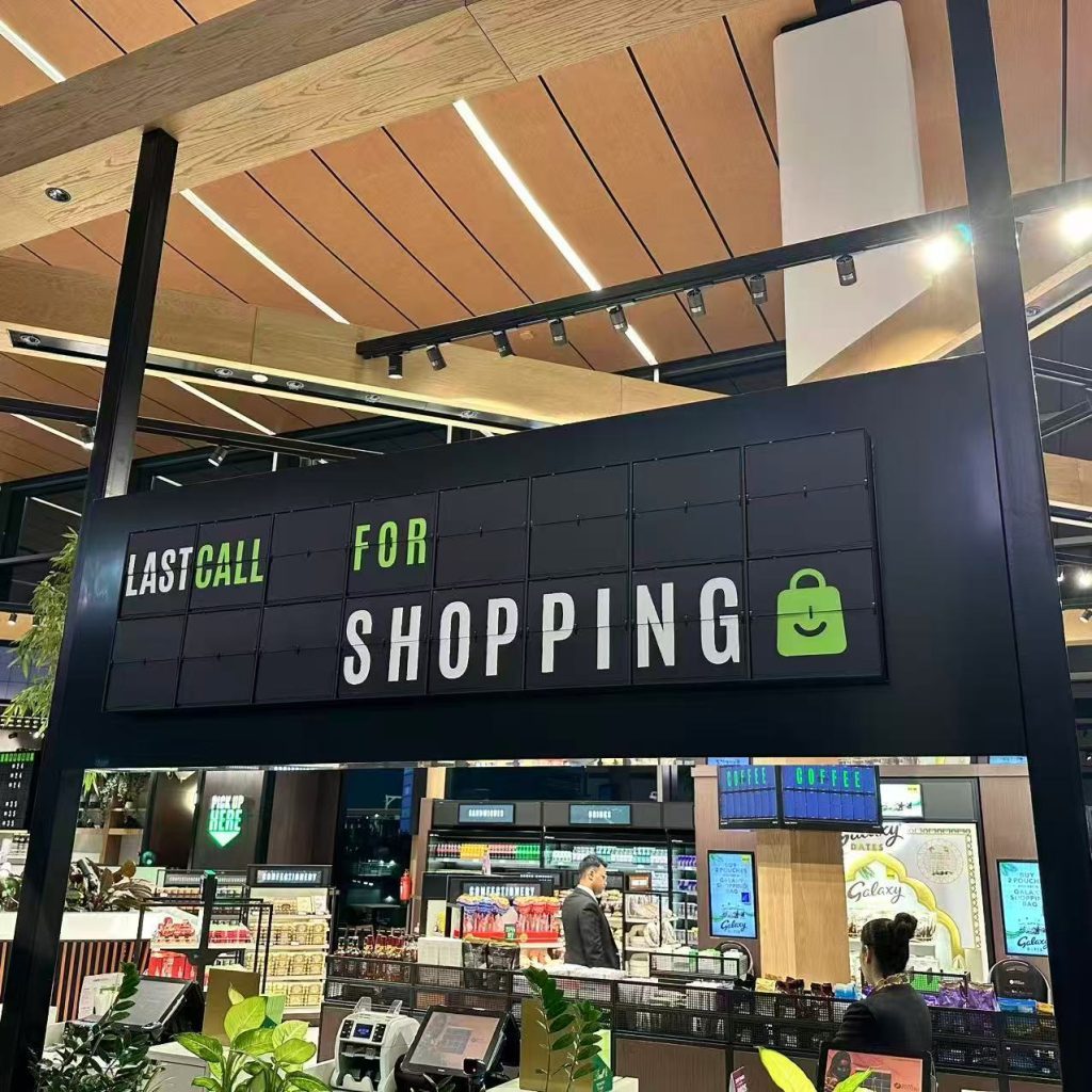 Custom airport shopping split flap display showing “Last Call for Shopping” inside a modern airport retail area.
