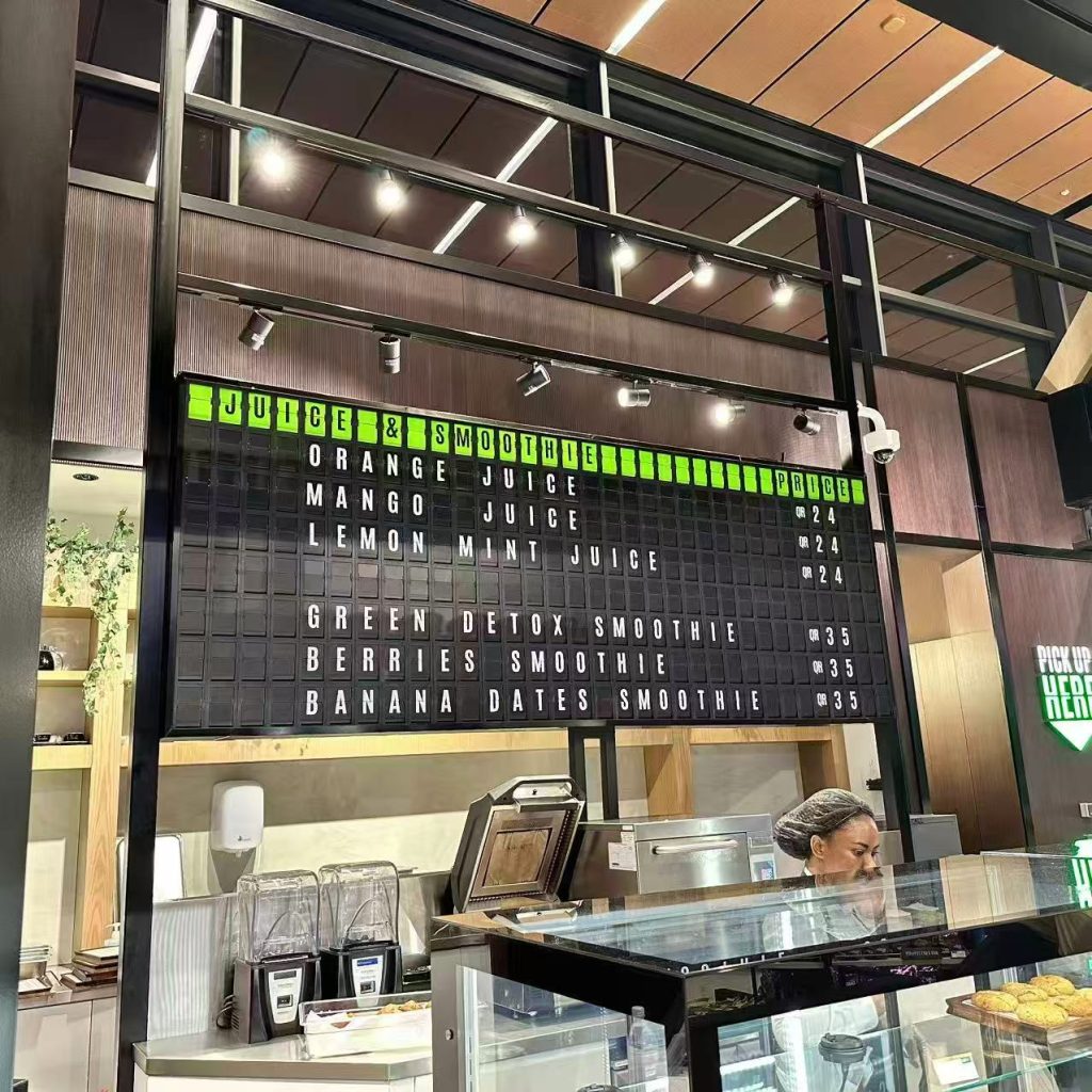 Custom split flap menu board showing juice and smoothie prices at LASTCALL restaurant in Hamad International Airport