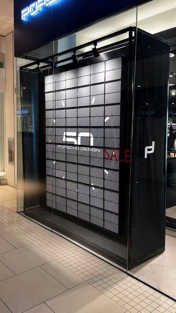 Picture Flap Display showing Porsche Design 50th anniversary graphics inside a retail store window