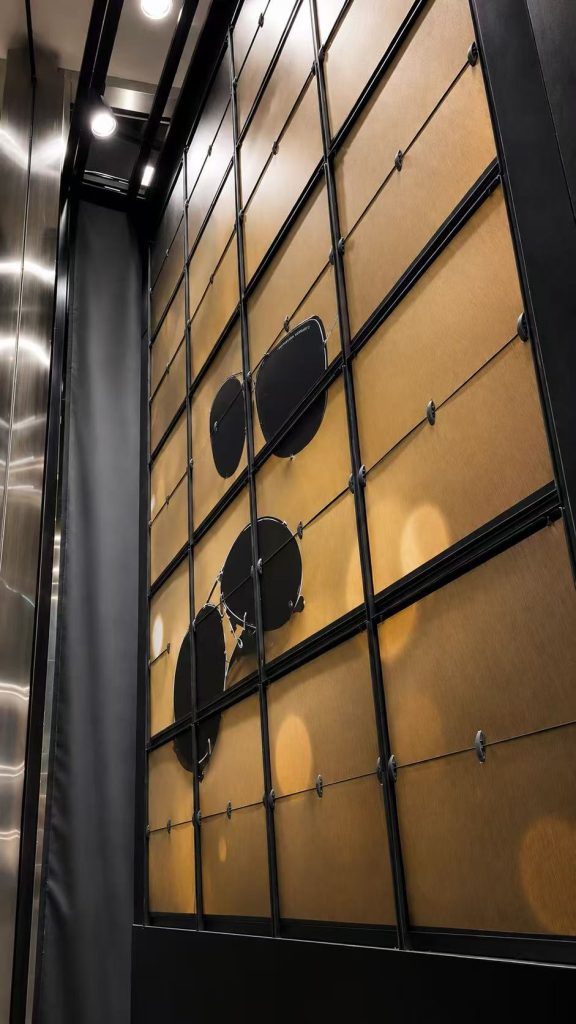 Close-up of a Porsche Design Picture Flap Display showing sunglasses on a gold background