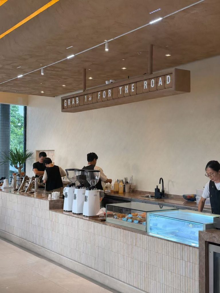 Oak-tone split flap display showing “GRAB 1 FOR THE ROAD” inside SANDORI Cafe in Davao, Philippines