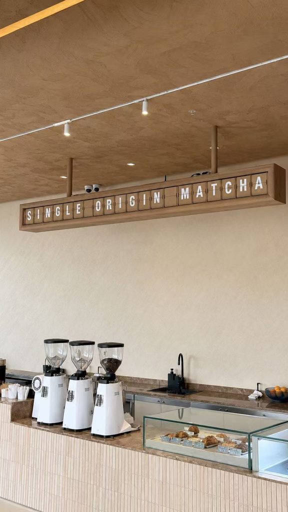Oak-tone split flap display showing “SINGLE ORIGIN MATCHA” above the counter at SANDORI Cafe in Davao, Philippines