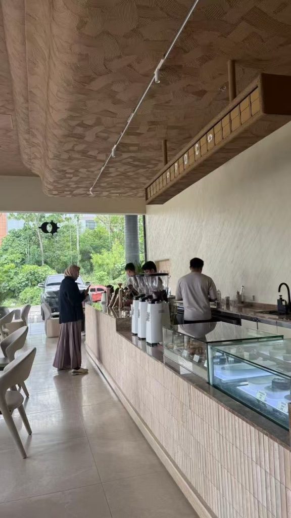 Oak-tone split flap display installed inside SANDORI Cafe in Davao, Philippines with a warm cafe interior