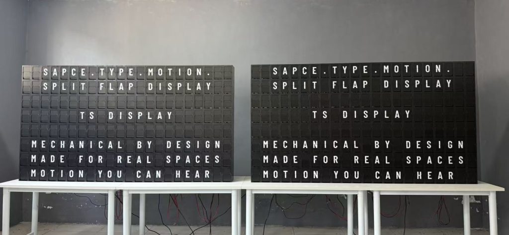 Two large split flap displays undergoing functional testing at the TS Display workshop before shipment.