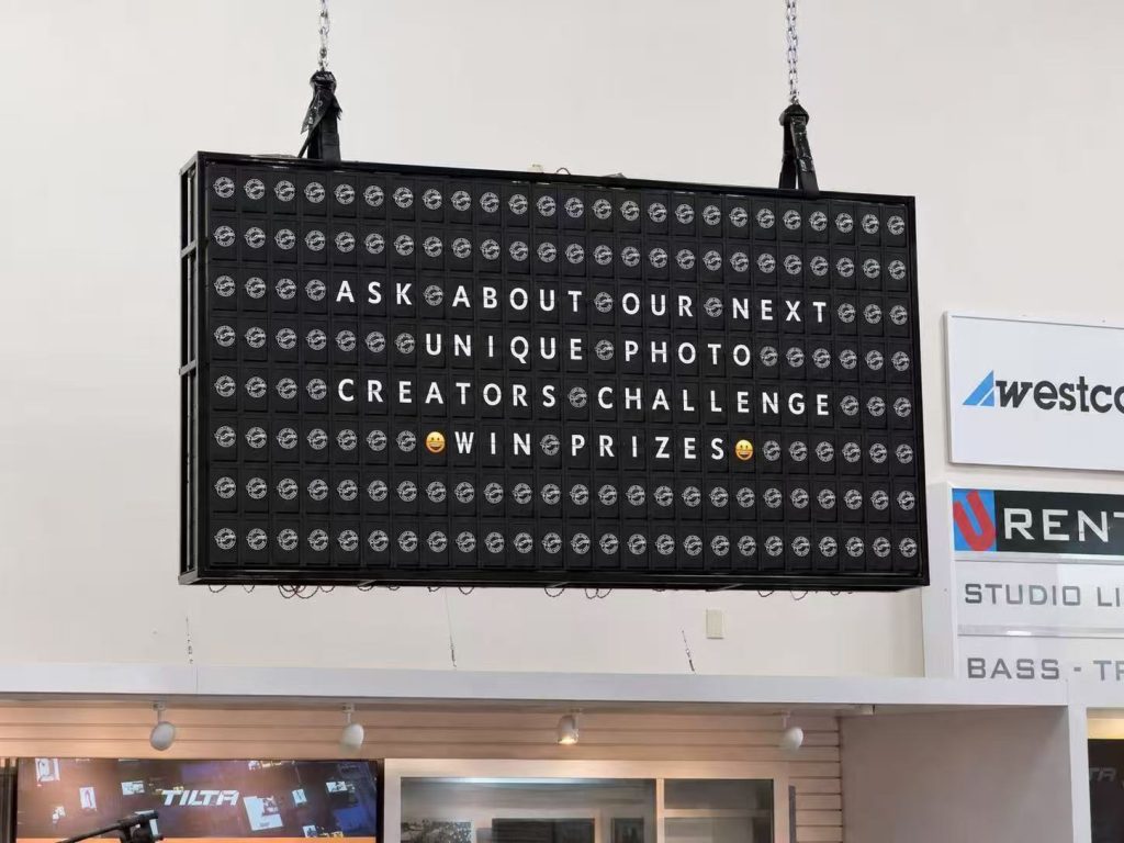 192 module split flap board displaying promotional messages at Unique Photo